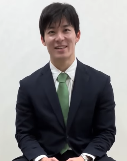 椅子に座って微笑む石田嵩人知事