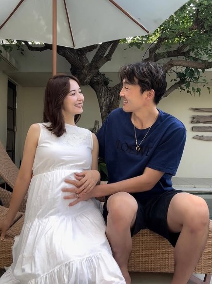 源田選手が妻の大きなお腹に手を触れ微笑んでいる画像