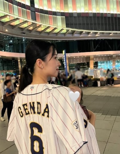 子供を抱っこして源田のユニホーム来て球場をバッグに撮った画像