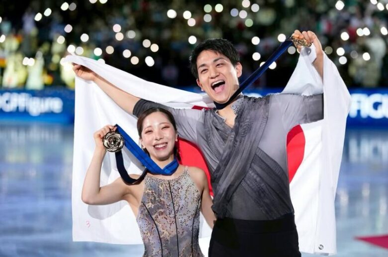 りくりゅうペアがメダルと日本国旗を持つ画像