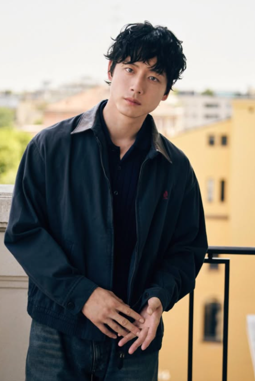 街並みをバッグにポーズをとる坂口健太郎