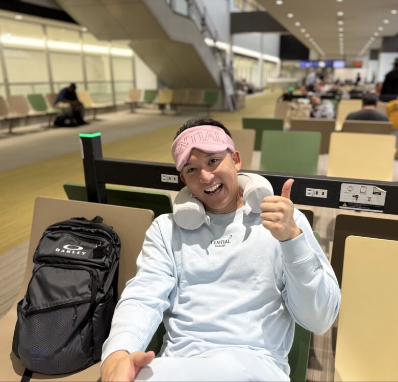 移動中の待合席で親指を立てる杉谷拳士さん(仕事を減らさずアメリカと日本で2倍働く)
