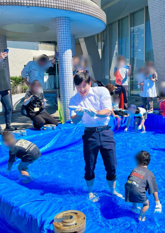 ズボンのすそを上げて足を見せている石田嵩人