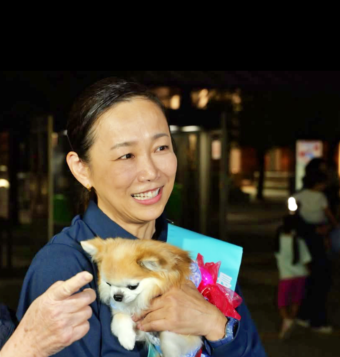 小型犬を抱く原沢敦美