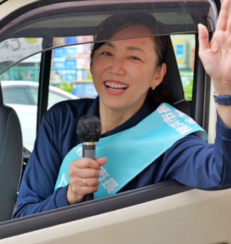 手を振り街頭活動をする原沢敦美