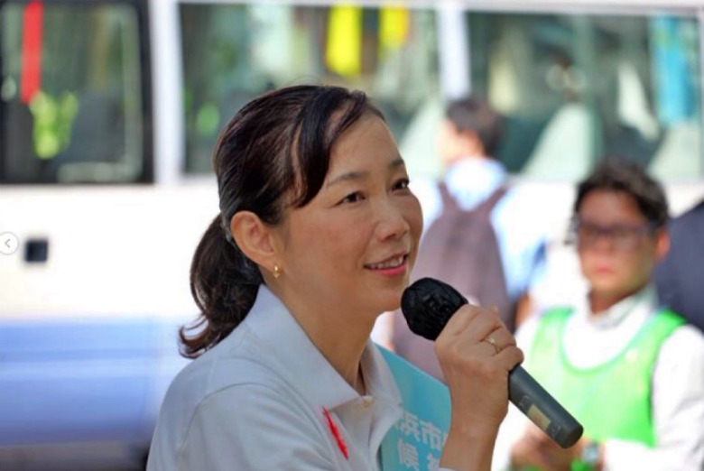 微笑みを浮かべながら演説をする原沢敦美