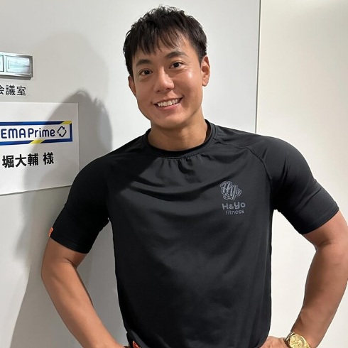 腰に手を当ててほほ笑む堀大輔