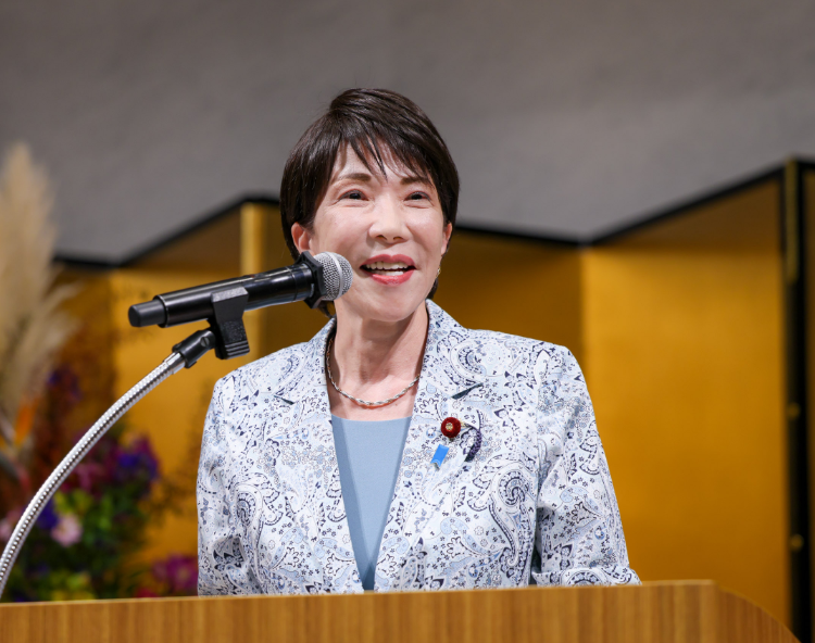 演壇で笑顔を見せて話す高市早苗さん(43歳で子供3人の母に)