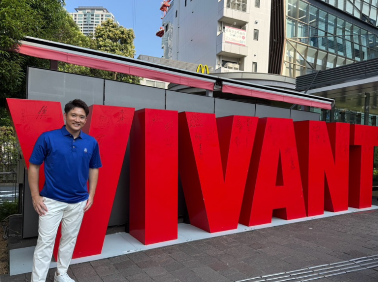VIVANTの文字の前で笑顔を見せる杉谷拳士さん(ご報告に別班の予想が集まった理由)